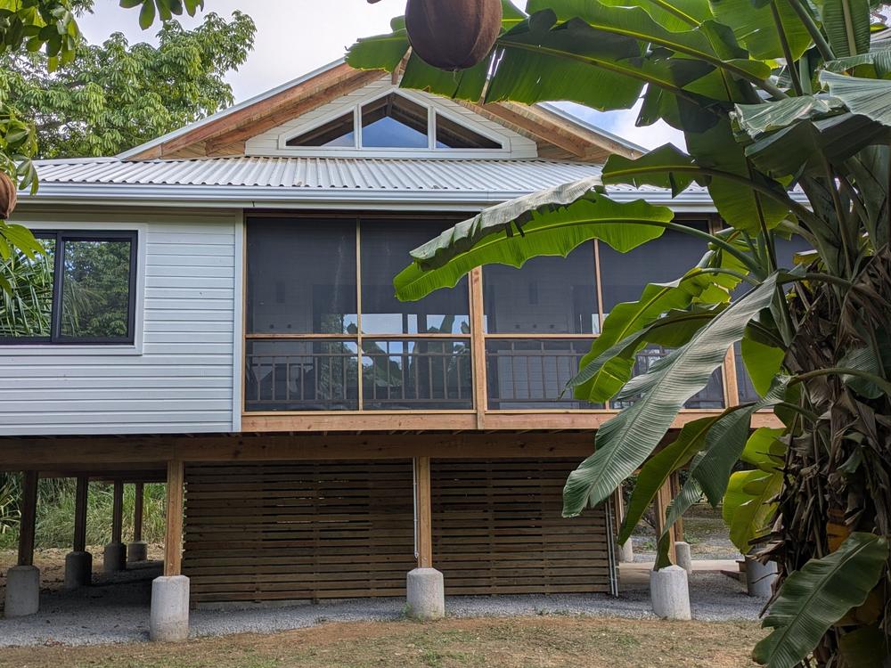 Maison sur pilotis et sa véranda moustiquaire